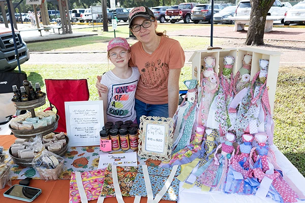 mother and daughter smiling at their vendor craft table
