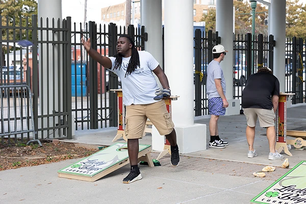 cornhole player tossing bag