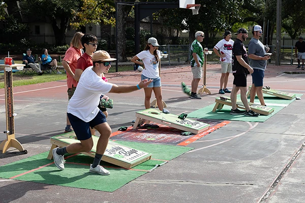 cornhole player tossing bag