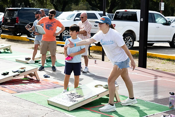 cornhole player tossing bag