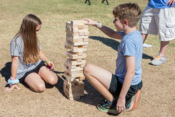 two kids playing outdoor jenga