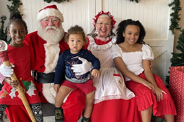 Christmas party - kids sitting with Santa and Mrs. Clause