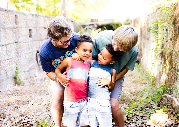 Moms leaning over and smiling down at sons