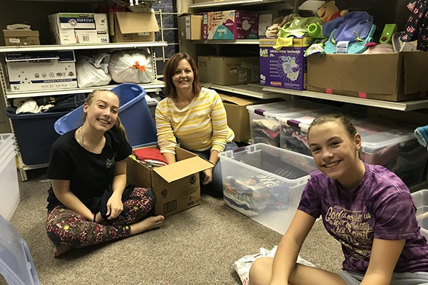 Three volunteers in the first storage room that was lent to Foster the Love LA.